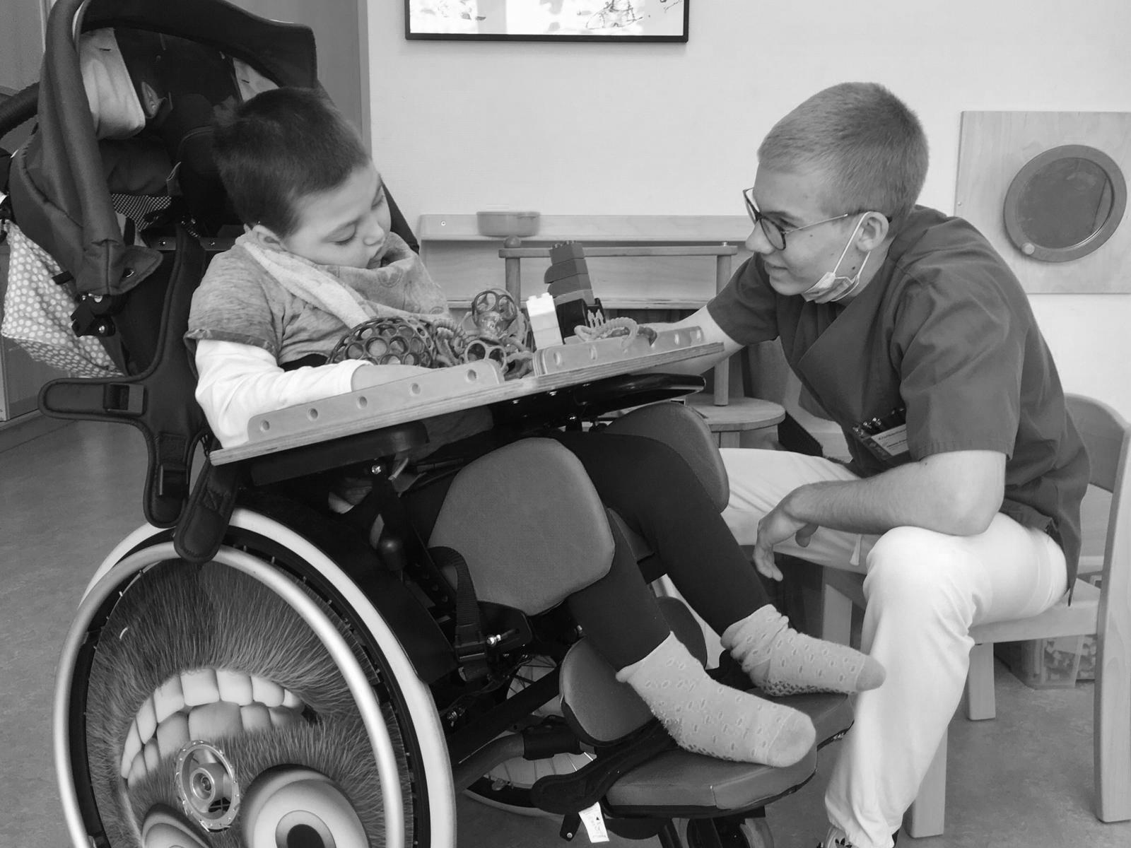 Krankenpfleger mit Kind im Rollstuhl